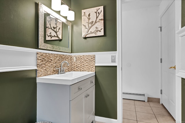 bathroom with tile patterned flooring, vanity, tasteful backsplash, and baseboard heating