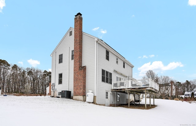 snow covered house featuring a deck and central air condition unit