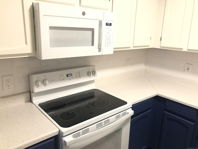 kitchen with backsplash, white appliances, white cabinets, and blue cabinets