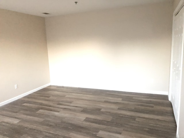 empty room with dark wood-type flooring