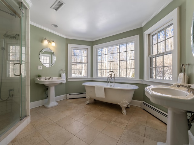 bathroom with ornamental molding, a baseboard radiator, visible vents, and a freestanding bath