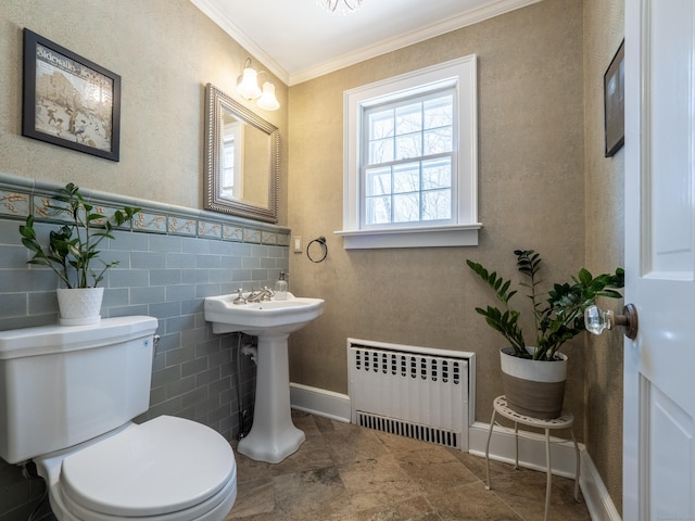 half bath featuring crown molding, toilet, radiator heating unit, wainscoting, and a sink