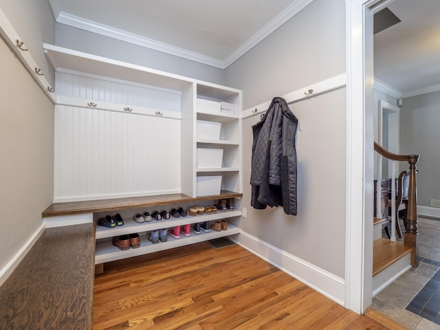 mudroom featuring baseboards, crown molding, and wood finished floors