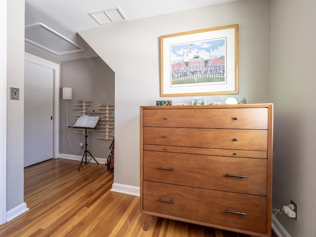 interior space with light wood-type flooring, visible vents, and baseboards