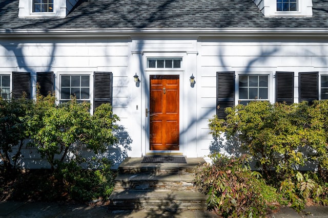 property entrance featuring a shingled roof