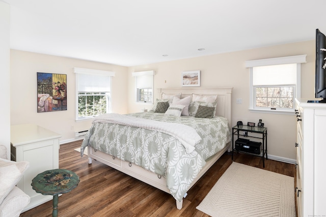 bedroom featuring dark wood finished floors, multiple windows, baseboards, and a baseboard radiator