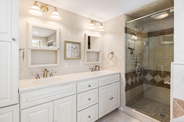 bathroom with a sink, double vanity, a shower stall, and tile patterned flooring