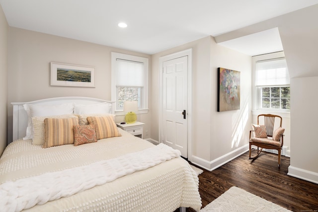 bedroom featuring dark wood-type flooring, baseboards, and a closet