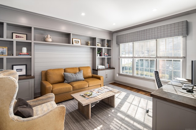 living area featuring recessed lighting, wood finished floors, baseboards, built in features, and crown molding