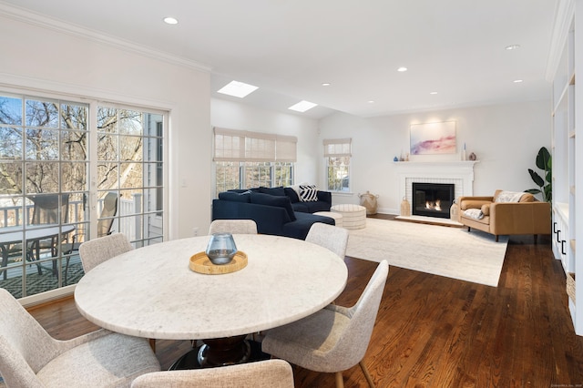 dining area with dark wood-type flooring, a fireplace, and recessed lighting