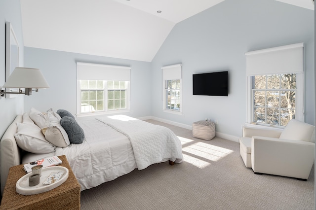 bedroom with baseboards, vaulted ceiling, and light colored carpet