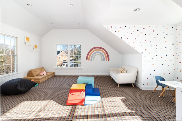 interior space with lofted ceiling, dark colored carpet, and baseboards