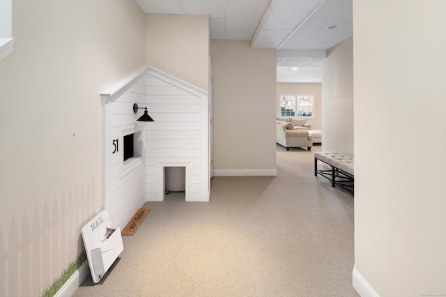 playroom featuring carpet floors, a drop ceiling, heating unit, and baseboards