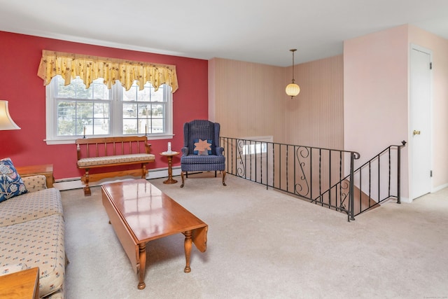 living area featuring carpet flooring, an upstairs landing, baseboards, and a baseboard radiator