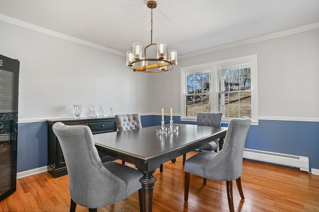 dining room with a chandelier, baseboards, light wood-style floors, ornamental molding, and baseboard heating