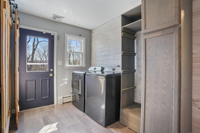 clothes washing area featuring laundry area, a baseboard radiator, light tile patterned floors, and separate washer and dryer