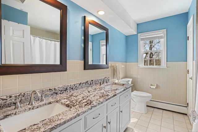 bathroom featuring toilet, a baseboard radiator, a sink, and tile patterned floors