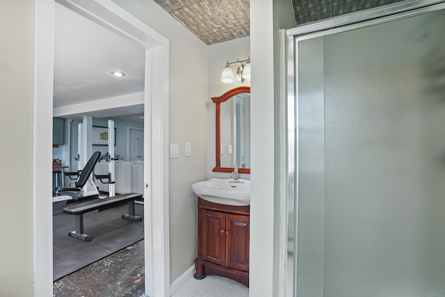 bathroom featuring a stall shower, vanity, and baseboards