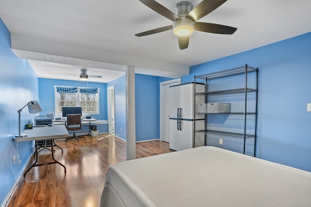 bedroom with a ceiling fan, baseboards, and wood finished floors