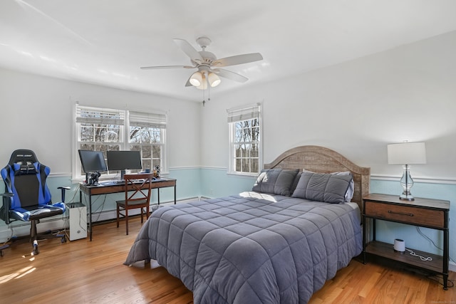 bedroom with wainscoting and wood finished floors