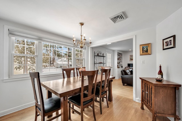 dining area featuring a chandelier and light hardwood / wood-style floors