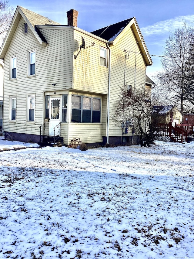 view of snow covered rear of property