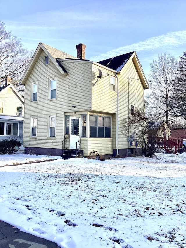 view of snow covered back of property