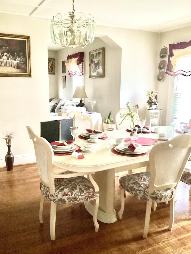 dining area with wood finished floors and a chandelier