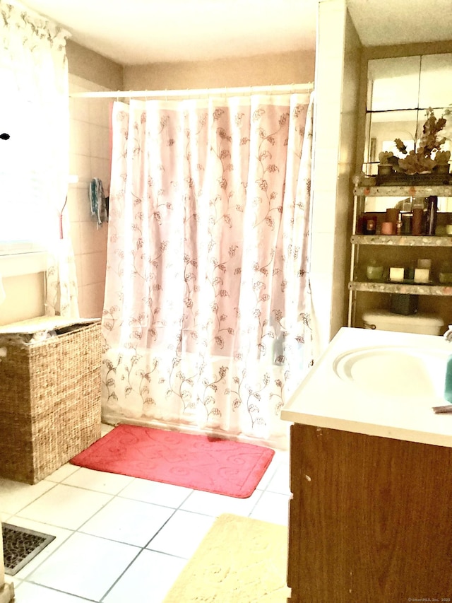 bathroom featuring tile patterned flooring, vanity, and shower / tub combo with curtain