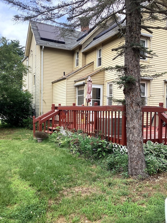 back of property featuring a deck and a yard