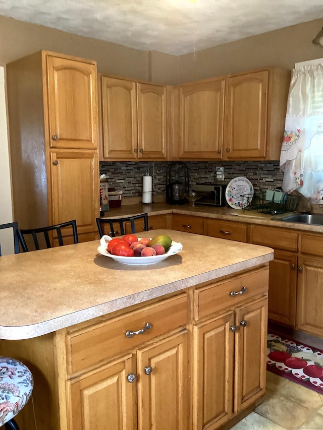 kitchen with decorative backsplash, light countertops, and a center island