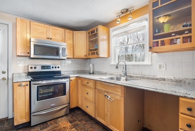 kitchen featuring appliances with stainless steel finishes, sink, light brown cabinets, and backsplash