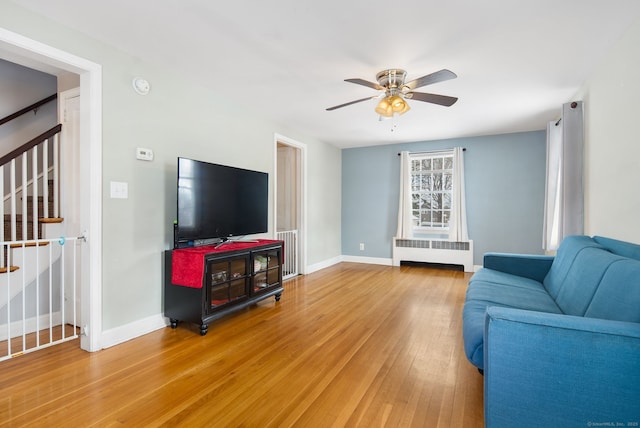 living room featuring hardwood / wood-style floors, radiator heating unit, and ceiling fan