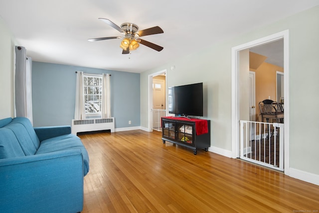 living room with hardwood / wood-style flooring, radiator heating unit, and ceiling fan