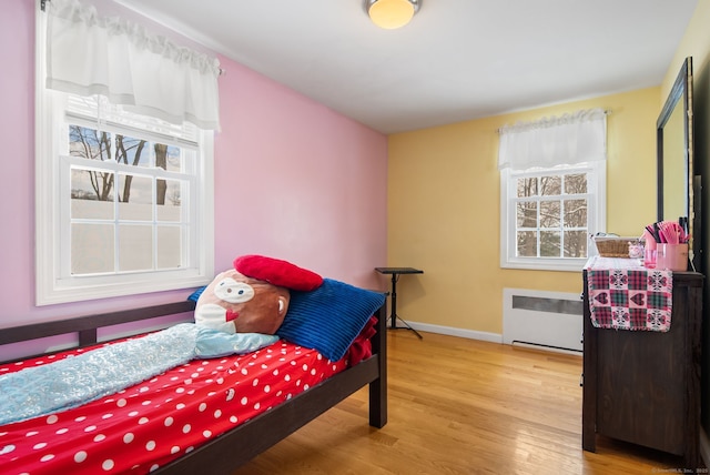 bedroom with hardwood / wood-style flooring and radiator