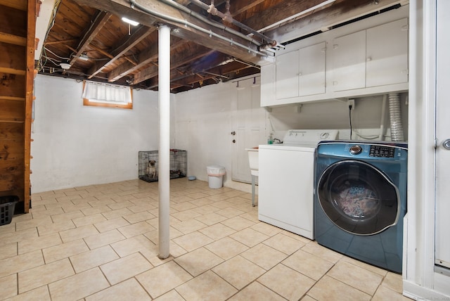 washroom with independent washer and dryer, cabinets, and light tile patterned floors