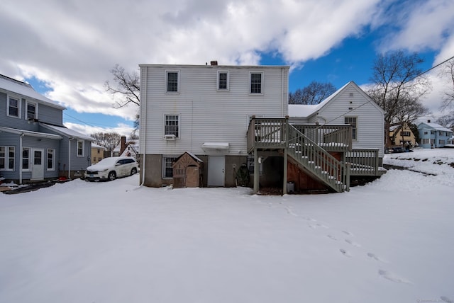 snow covered property with a wooden deck