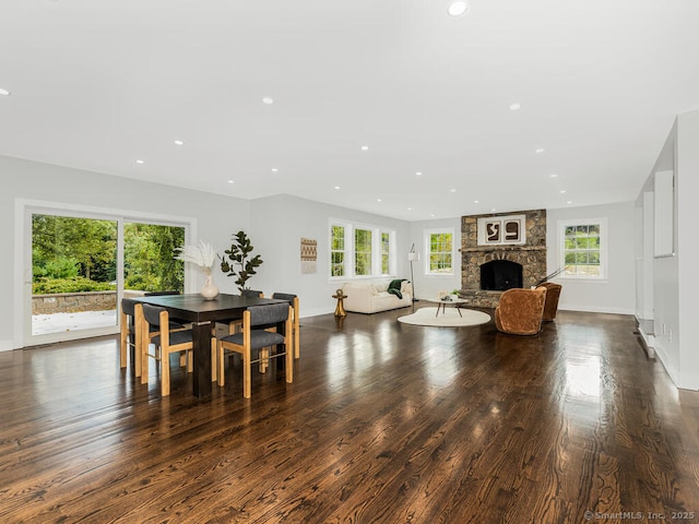 dining space featuring plenty of natural light, a fireplace, and dark hardwood / wood-style flooring