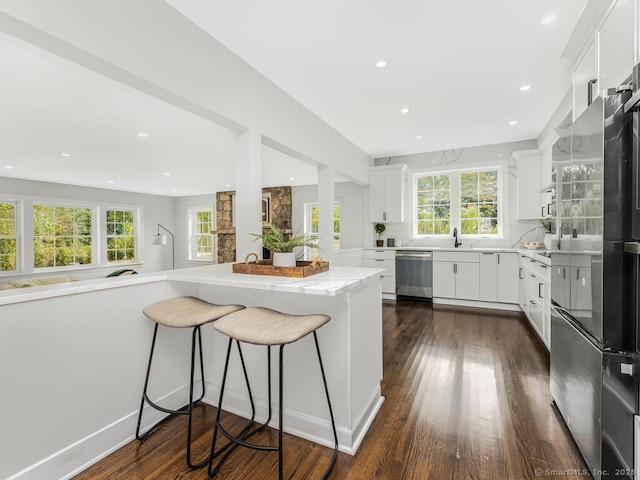 kitchen with stainless steel dishwasher, a kitchen bar, and kitchen peninsula