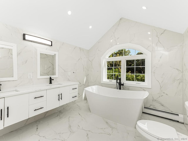 bathroom featuring vaulted ceiling, a bathtub, vanity, and baseboard heating