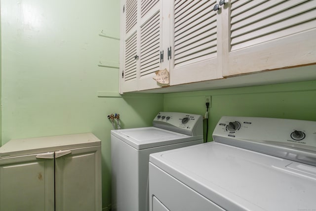 washroom featuring cabinets and separate washer and dryer