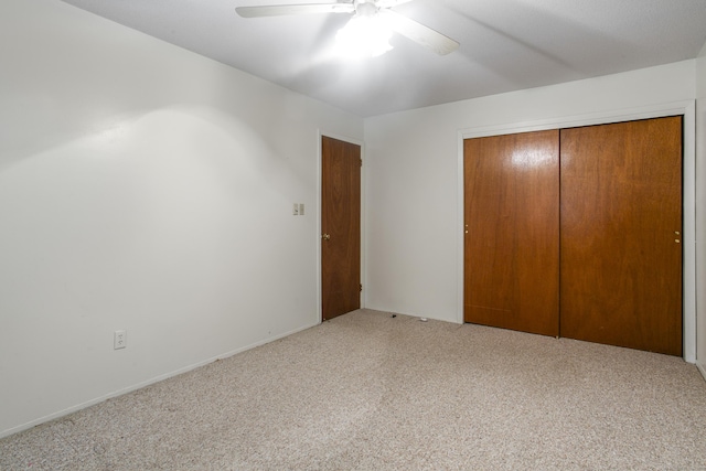 unfurnished bedroom featuring carpet floors, a closet, and ceiling fan