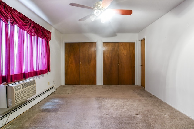 unfurnished bedroom with carpet floors, ceiling fan, a baseboard radiator, and multiple closets