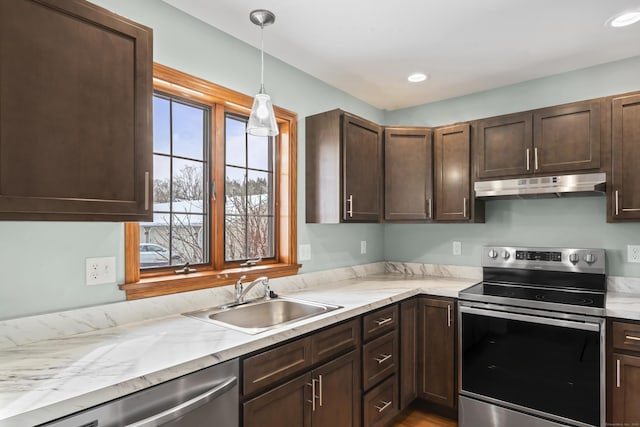 kitchen featuring sink, appliances with stainless steel finishes, hanging light fixtures, dark brown cabinetry, and light stone countertops