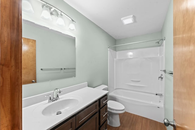 full bathroom with shower / bathing tub combination, vanity, hardwood / wood-style flooring, and toilet