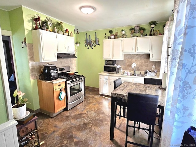 kitchen with tasteful backsplash, white cabinetry, appliances with stainless steel finishes, and sink