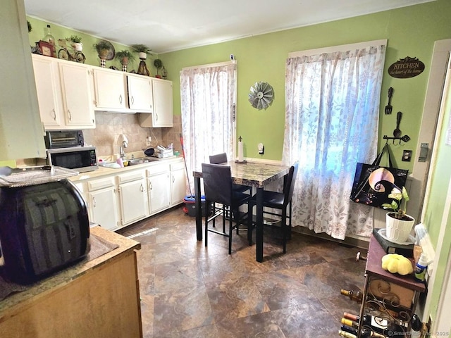 kitchen with sink, decorative backsplash, and white cabinets