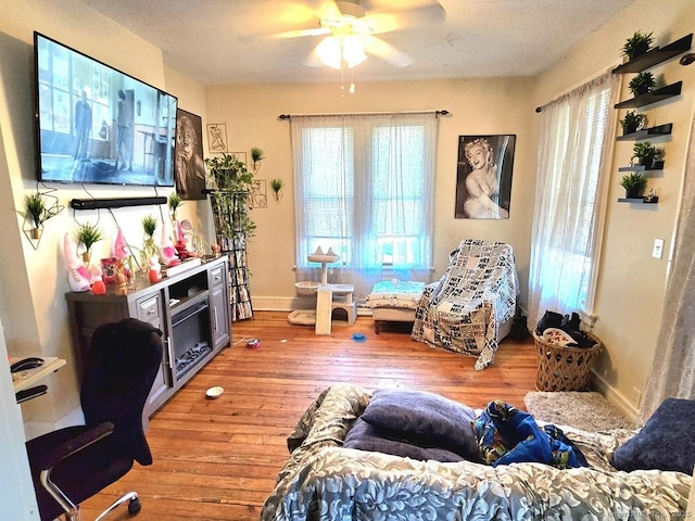 living room featuring wood-type flooring and ceiling fan