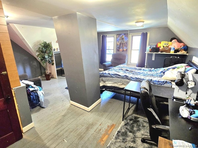 bedroom with wood-type flooring and lofted ceiling