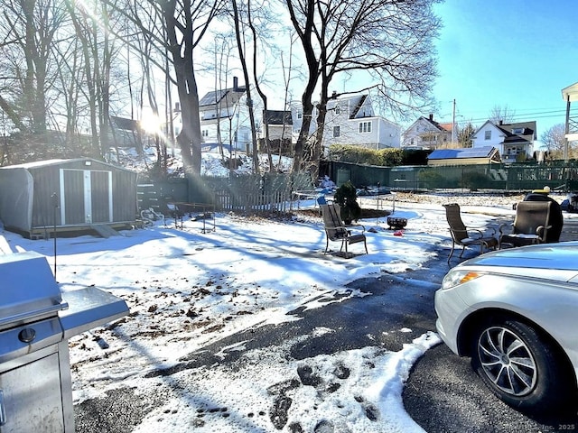 yard covered in snow featuring a shed